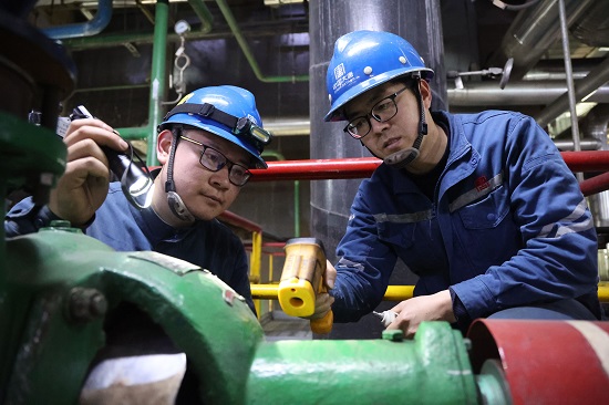 李志國（右一）和馮文輝（左一）在測量膠球泵軸承振動頻次和溫度 - 副本.jpg